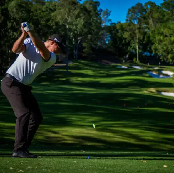 A man swings a golf club on a green course. | Featured Image for the Country Club and Golf Course | Brookwater Golf and Country Club home page